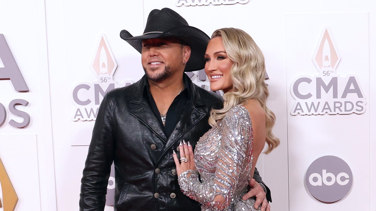 Jason Aldean y Brittany Aldean posando juntos en la alfombra roja