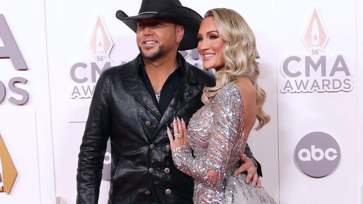 Jason Aldean and Brittany Aldean posing together on the red carpet