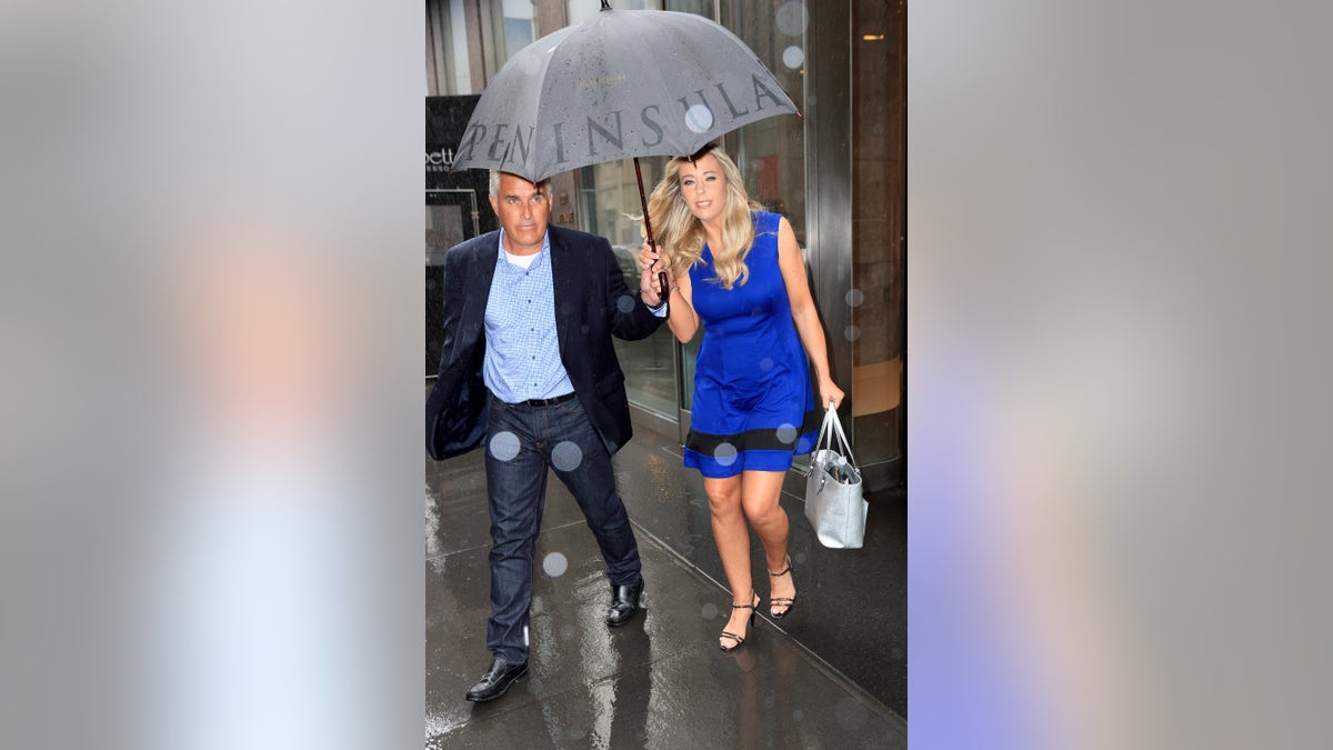 Steve Neild holding an umbrella over Kate Gosselin in a blue dress