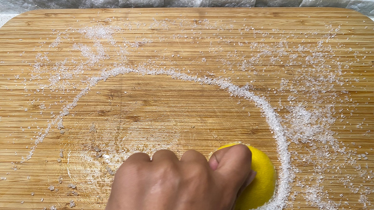 Sliced lemon rubbed onto cutting board.