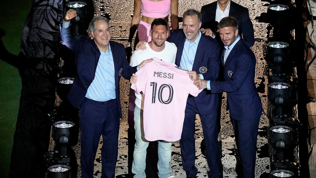 Lionel Messi holds pink jersey