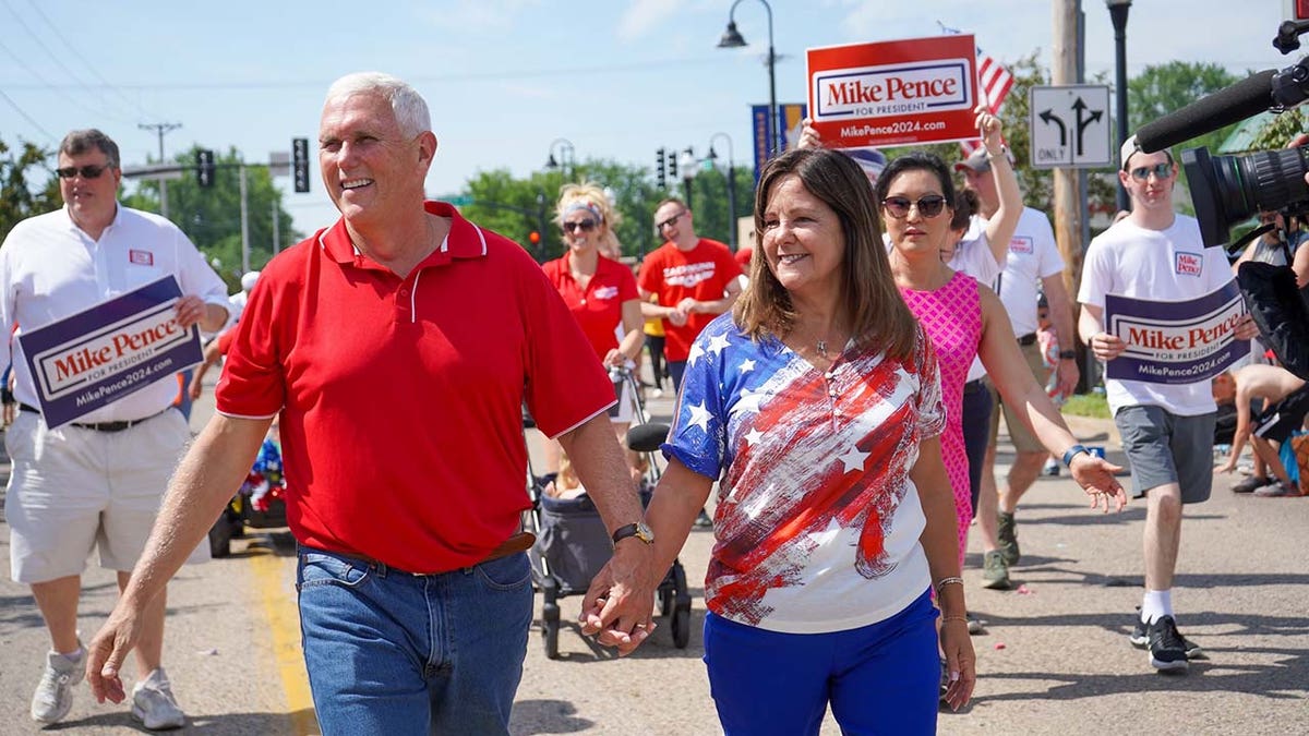 Former Vice President and 2024 Presidential Candidate Mike Pence walks alongside Karen Pence in the Urbandale 4th of July Celebration