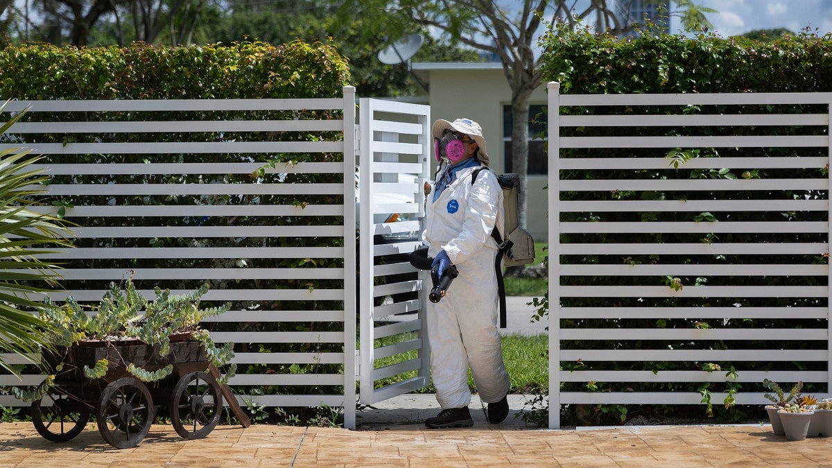 A Miami-Dade Mosquito Control inspector sprays a pesticide to kill mosquitos
