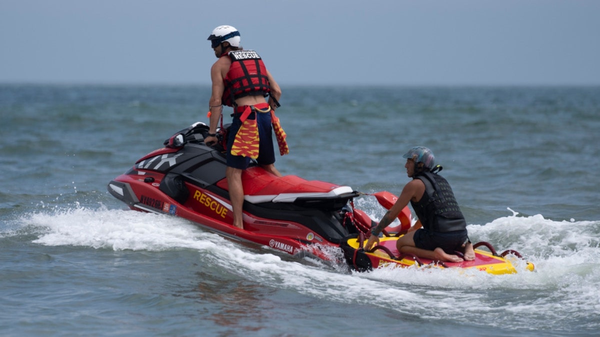 New York lifeguards ride a jet ski during a shark patrol run