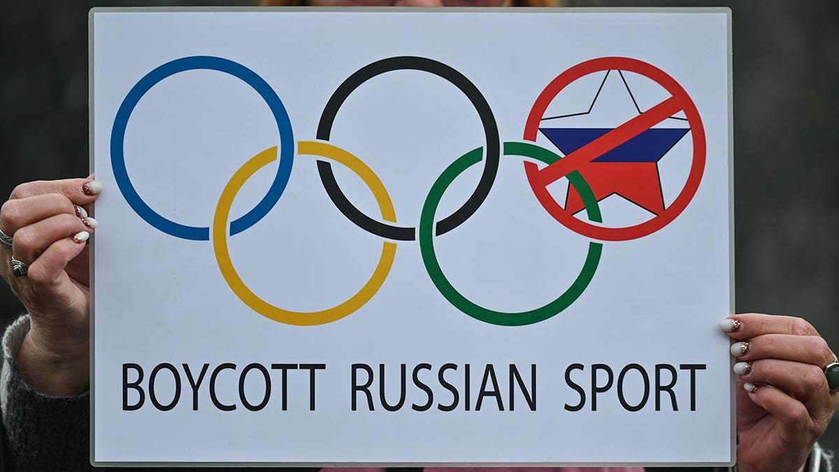Protester holds a 'Boycott Russian Sport' sign