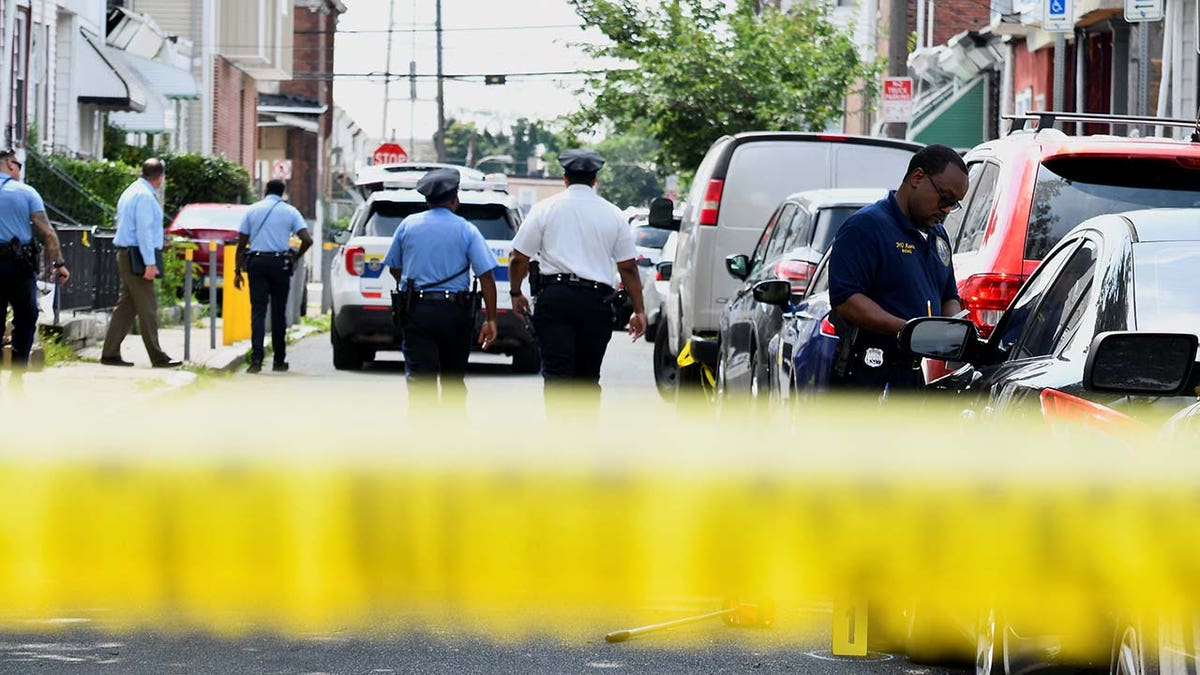 Police officers work at the scene the day after a shooting in Philadelphia
