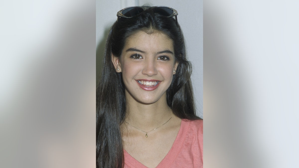 Phoebe Cates smiling with sunglasses on her head