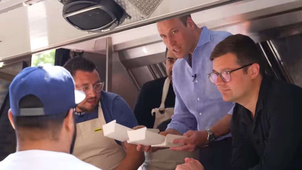 Prince William holding burgers in a food truck