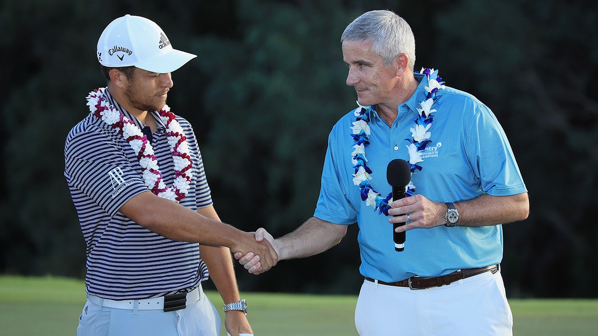 Xander Schauffele aperta a mão do comissário do PGA Tour