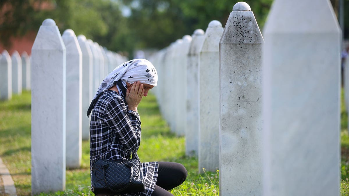 Bosnian woman mourning at grave