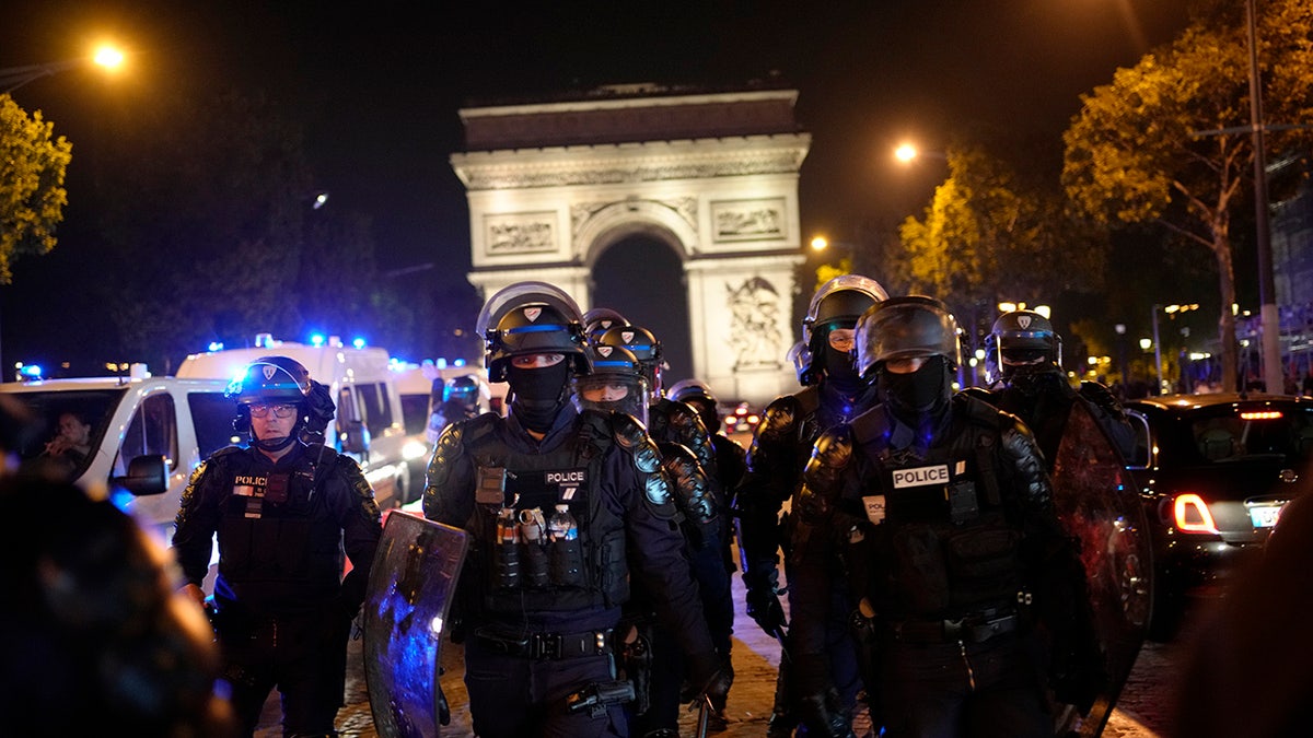 French police in riot gear march near Arc de Triomphe