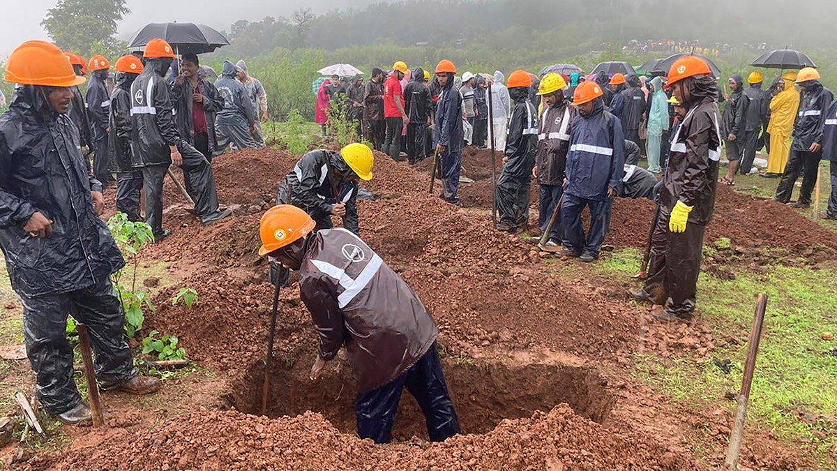 Rescuers dig a grave to bury a victim
