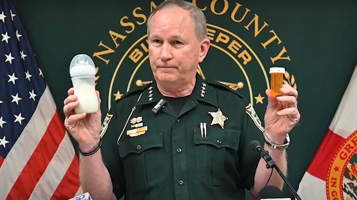 Nassau County Sheriff Bill Leeper holding rx bottle left hand, baby bottle right