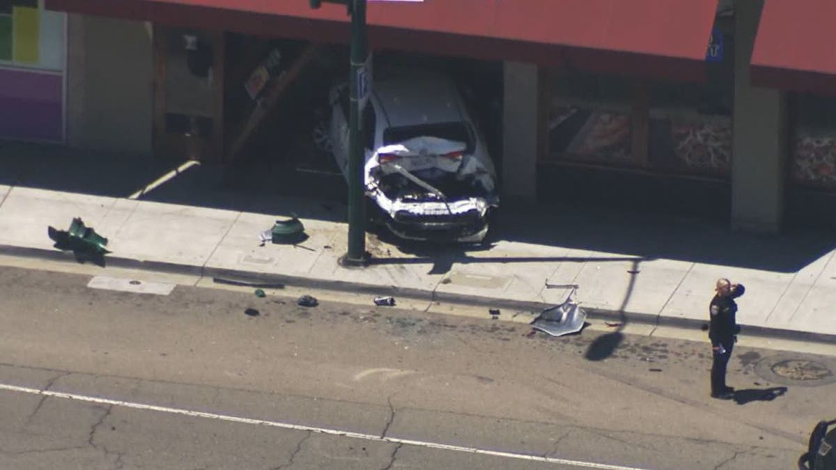 Damaged car next to pizza shop