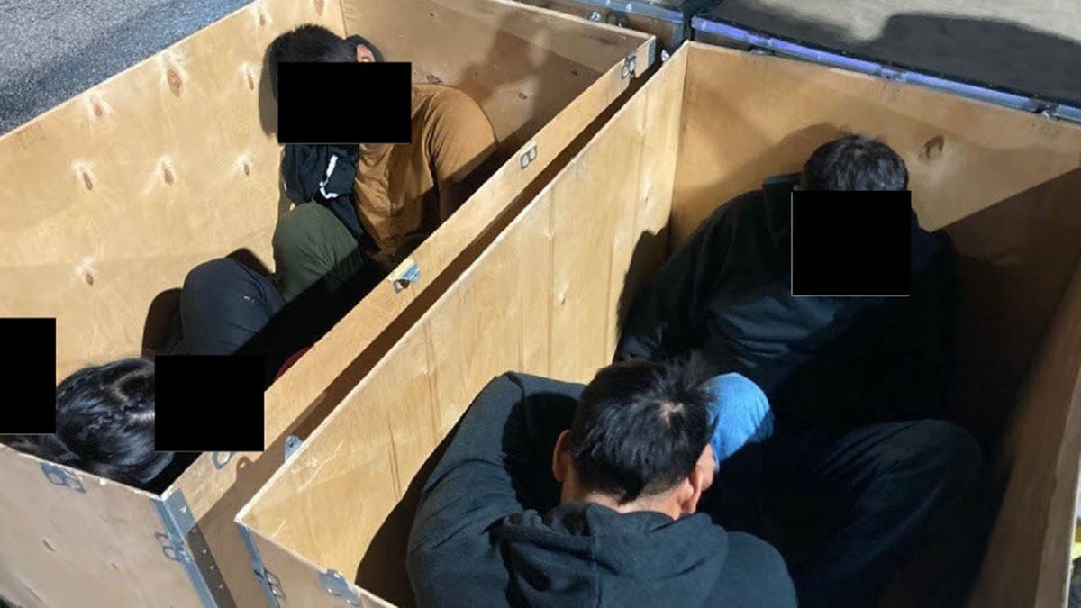Migrants inside a wooden crate