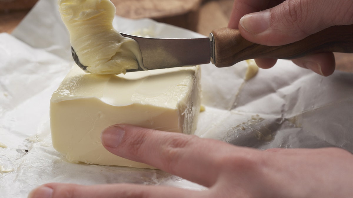 Person uses standard butter knife to cut butter.