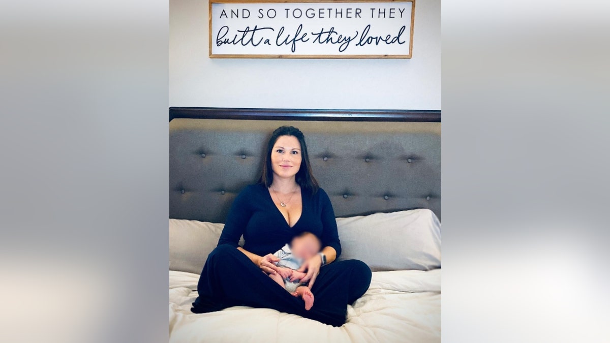 Krystal Talavera sitting on a bed with her baby
