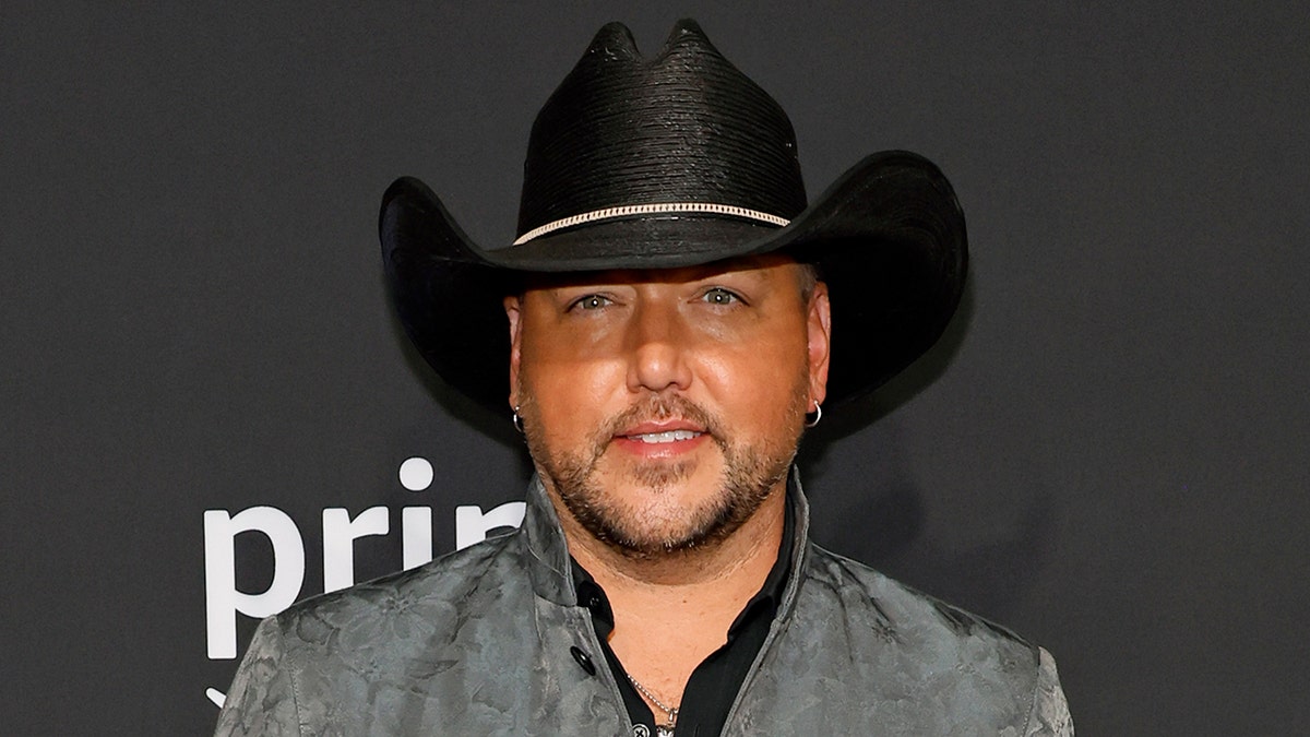 Jason Aldean walks CMAs red carpet wearing black cowboy hat