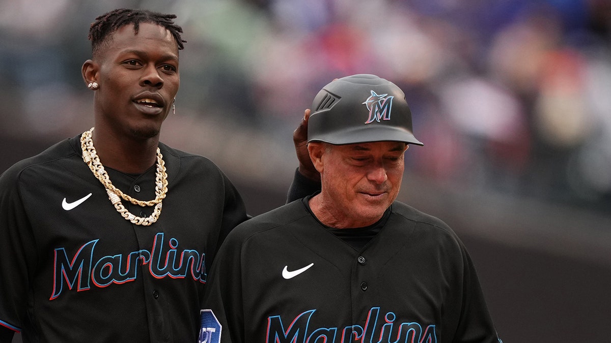 Jazz Chisholm Jr., left, of the Miami Marlins hands his equipment to third base coach Jody Reed during the game against the New York Mets at Citi Field in New York City on April 7, 2023.