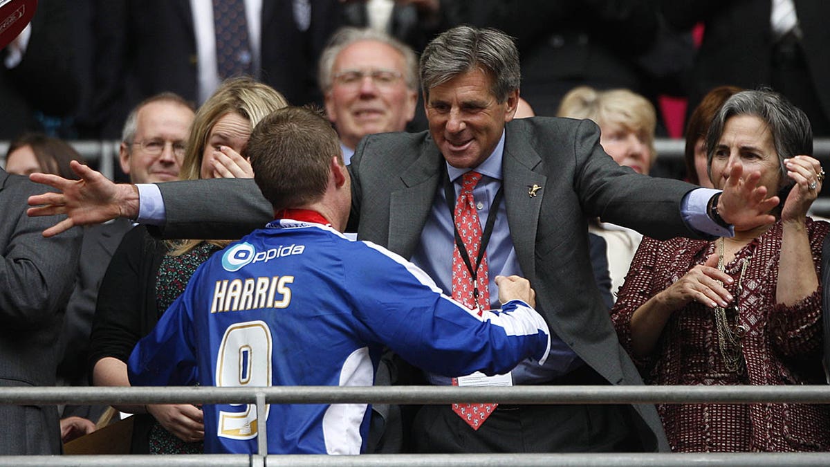Millwall chairman John Berylson hugs a player from the stands