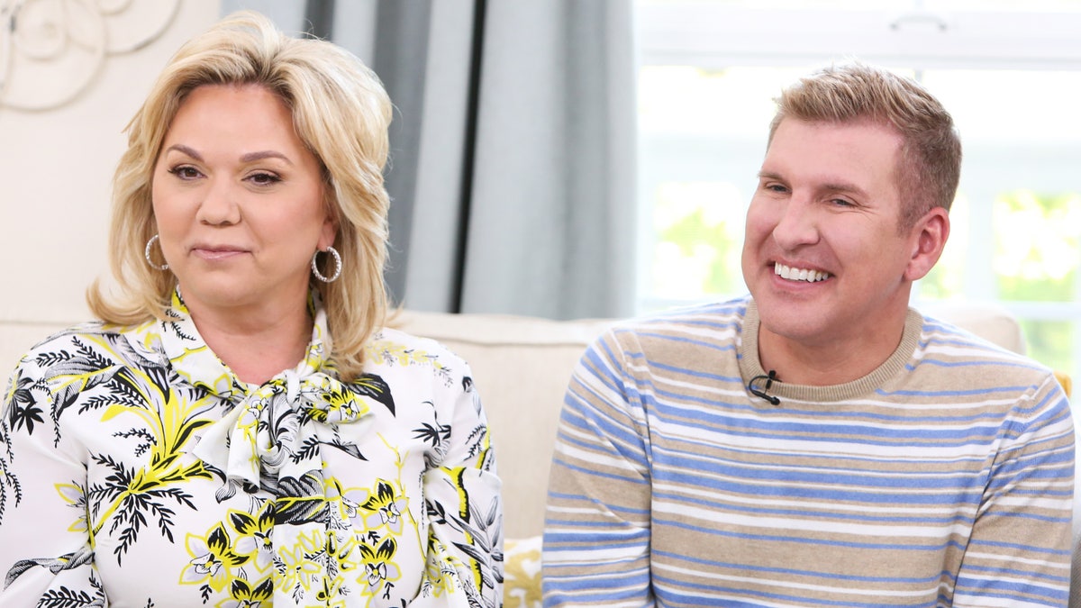 Julie and Todd Chrisley sit on a couch