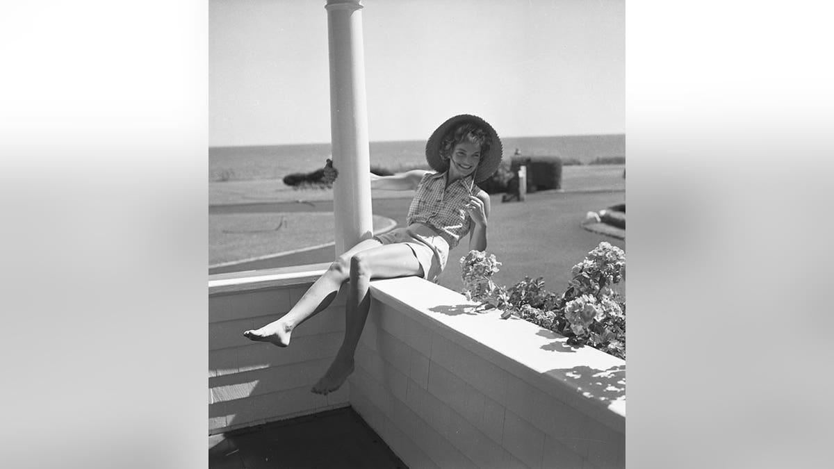 Jackie Kennedy leans back on a balcony in Hyannis Port