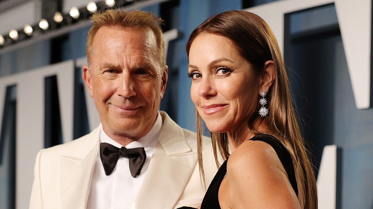 Kevin Costner wears white suit at Oscars after-party with Christine Baumgartner