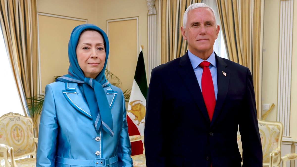 Maryam Rajavi and Mike Pence stand next to each other