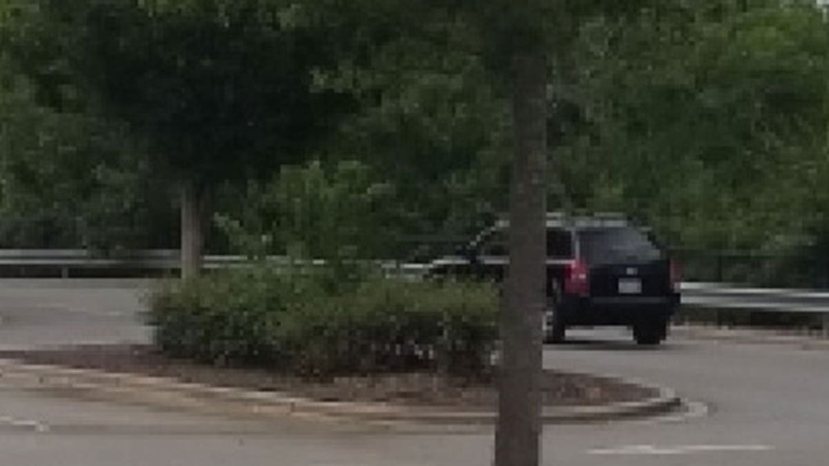 suspect SUV passing tree and leaving Walmart parking lot