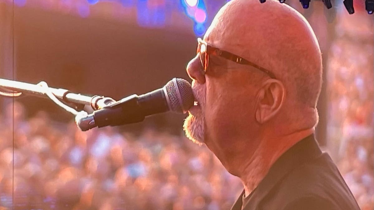 Billy Joel sings into microphone while performing on stage