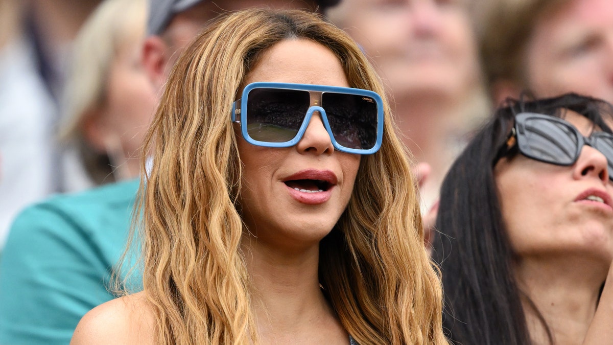 Shakira with large black sunglasses with blue trim around them at Wimbledon