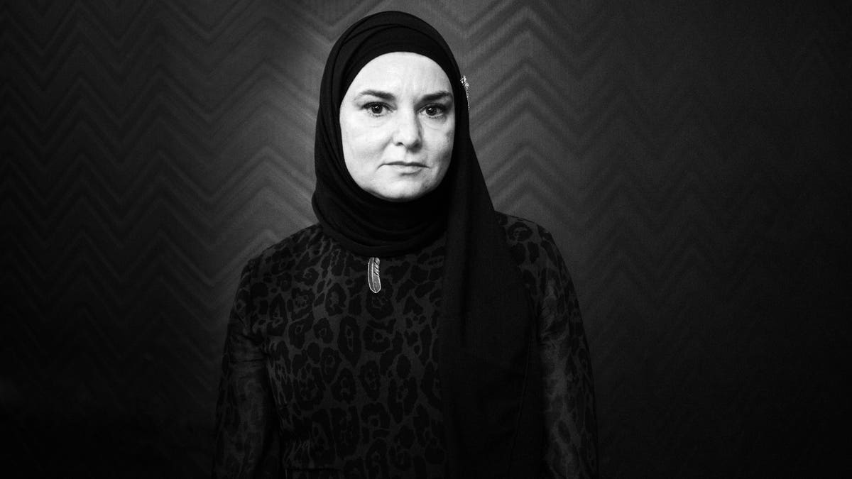 Sinéad O'Connor wears a headpiece over her head in a black and white photo