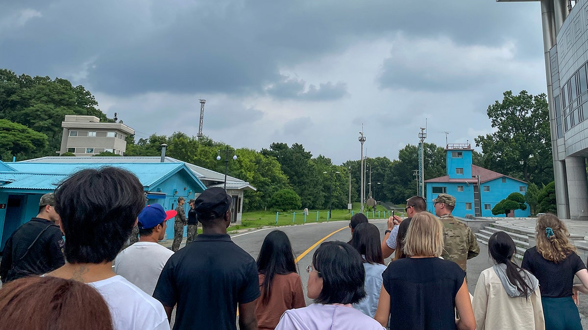 Tourists stand near a border station at Panmunjom in the DMZ between South and North Korea