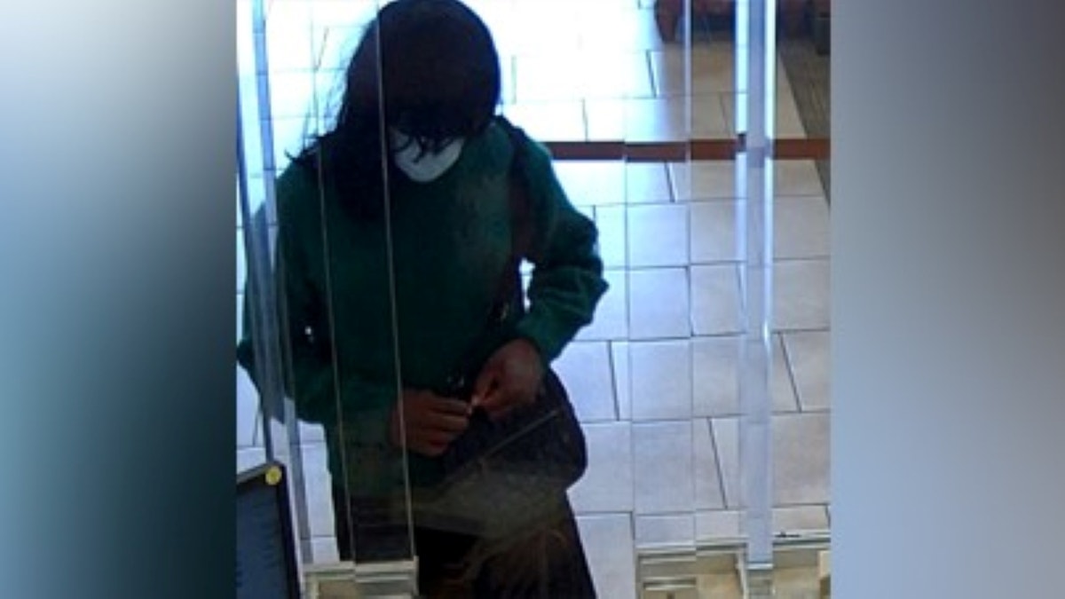 Suspect opening purse at bank