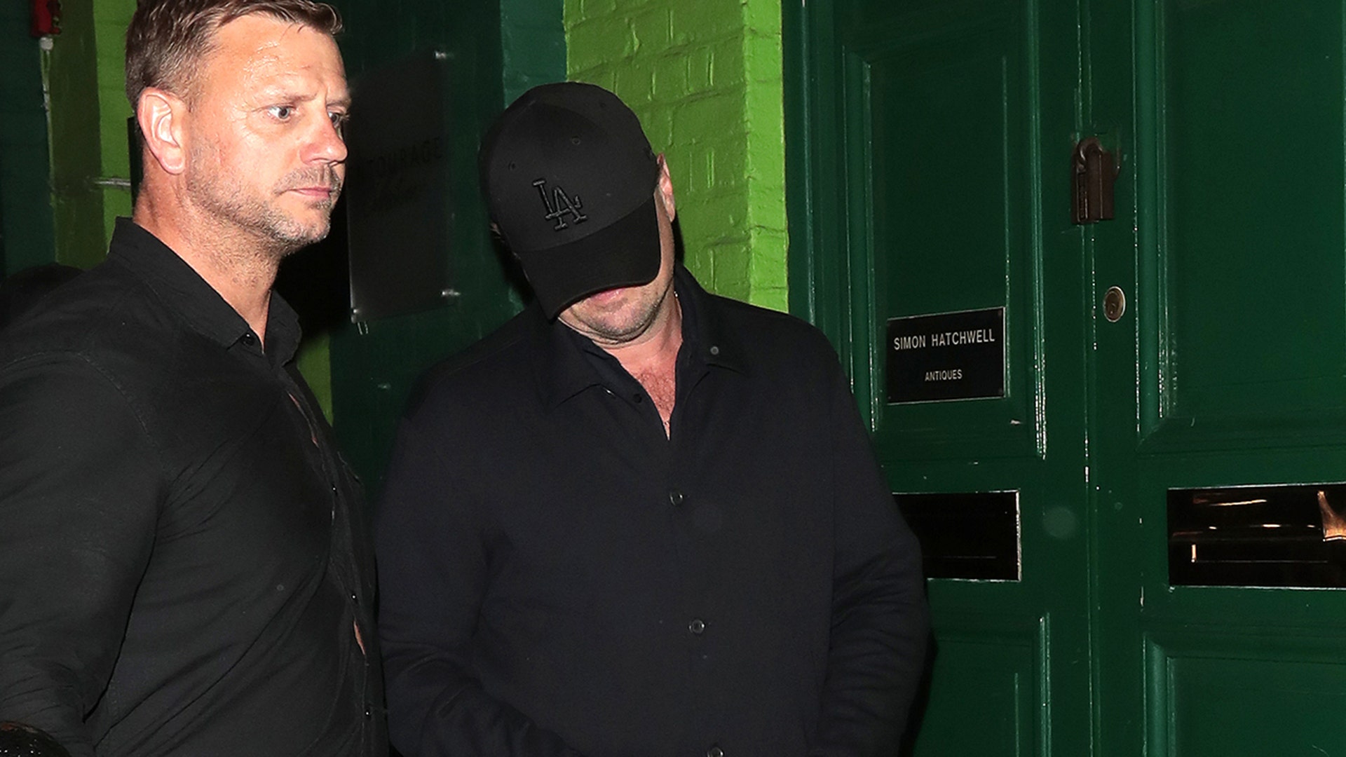 Leonardo DiCaprio leaving Mick Jagger's birthday party while covering his face