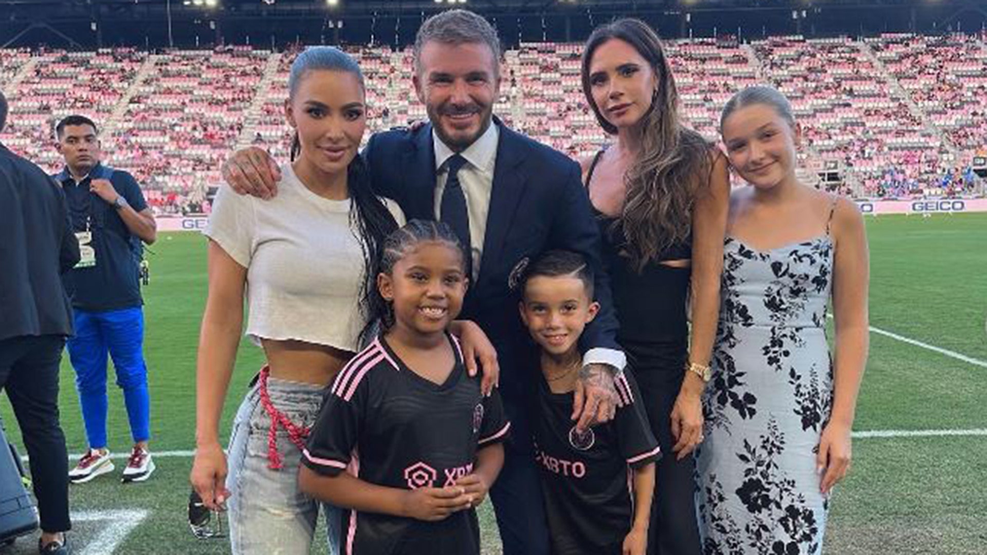 Kim Kardashian and Saint West taking a picture with David, Victoria and Harper Beckham