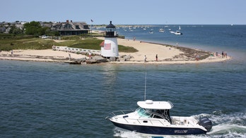 Beachgoers on edge as sharks seen prowling in blood-red waters: video