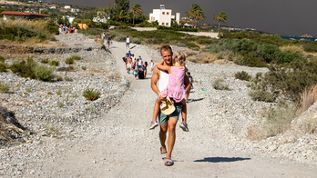 Tourists flee vacation destination 'in just swimsuits' as wildfires rage