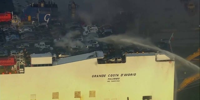 cars on deck of cargo ship with smoke
