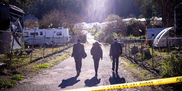 FBI officials walk towards the crime scene
