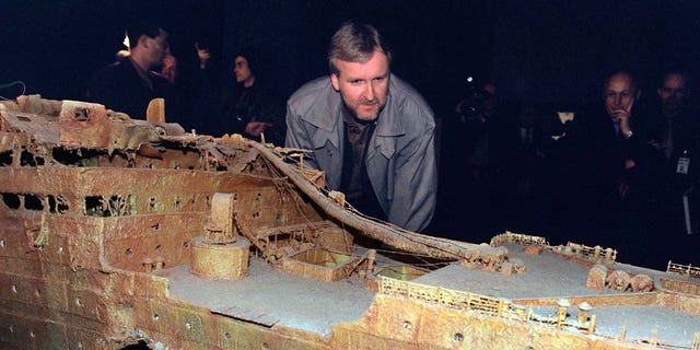 James Cameron looking at a model of the Titanic wreckage