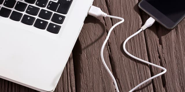 Bir dizüstü bilgisayara bağlı bir telefonun fotoğrafı.