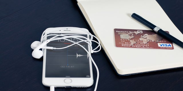 iPhone on desk with headphones wrapped around 