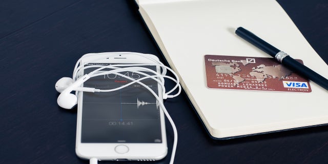 iPhone on desk with headphones wrapped around