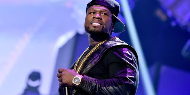 50 Cent performing with baseball cap