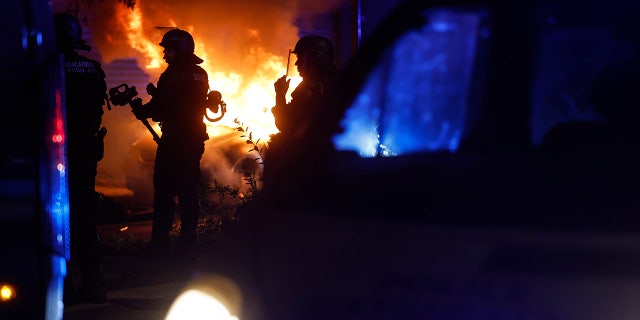 Car burning in the street as French police respond to riots