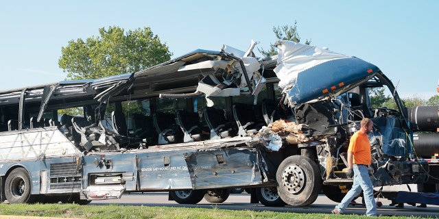 A worker helps clear the wreckage of a Greyhound bus