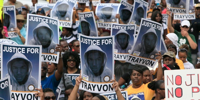 BLM celebra su décimo aniversario y pide que el 13 de julio sea el 'Día de Black Lives Matter' y renueva el impulso para desfinanciar a la policía Manifestantes con carteles