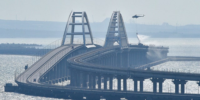 Helicopter drops water on bridge connecting Crimea and Russia