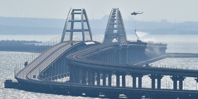 Helicopter drops water on bridge connecting Crimea and Russia